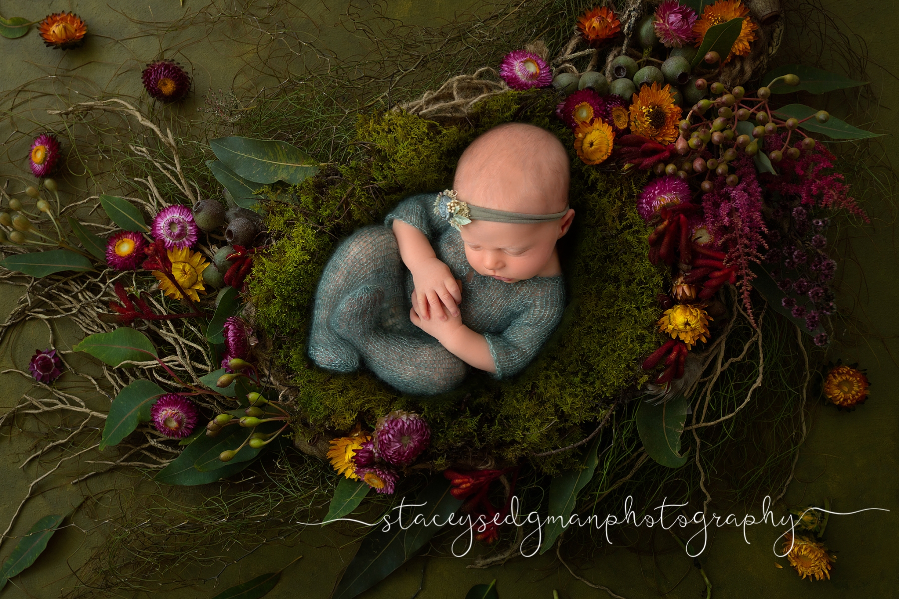 Newborn girl in green footed romper on green floral luisa dunn digital nackground